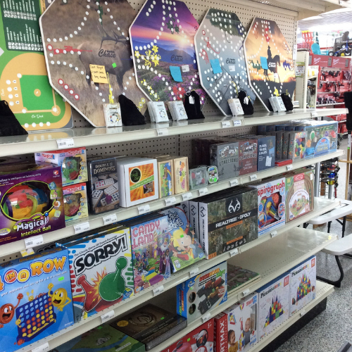 Store shelves filled with various board games and toys, including Sorry, Candy Land, and Spirograph. The display is colorful and inviting.